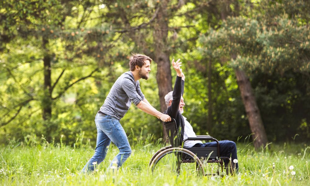 Man takes elderly person out in wheelchair