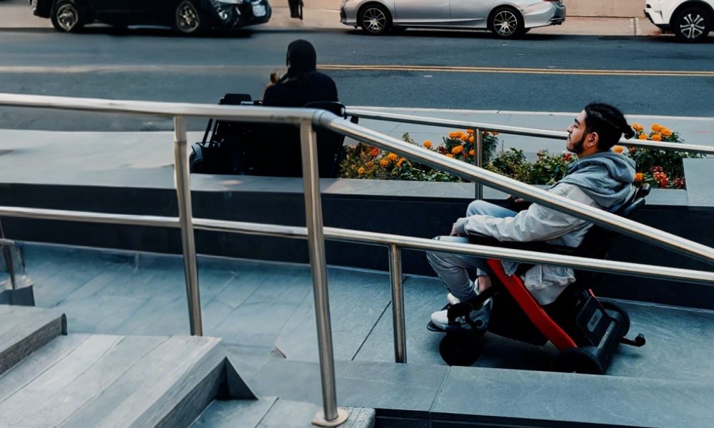 Man driving a red lightweight electric wheelchair