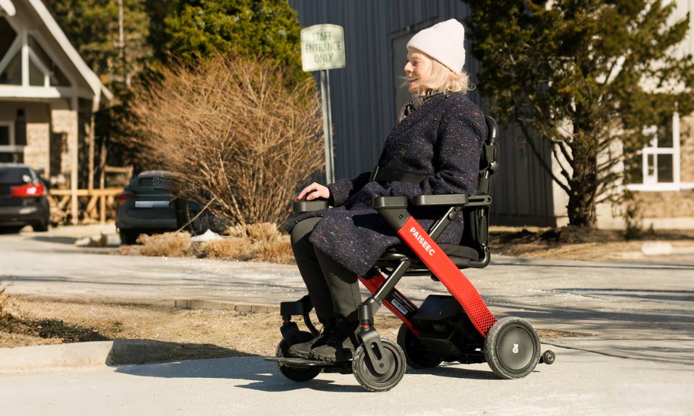 A lady sitting in a folding wheelchair and going out