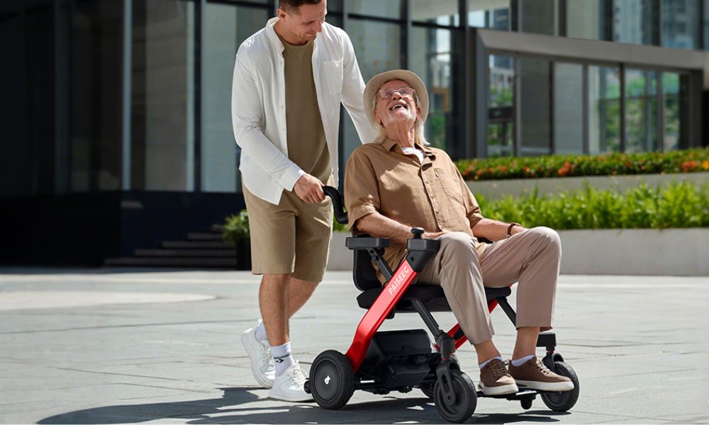 Man pushes electric wheelchair to take elderly for a walk