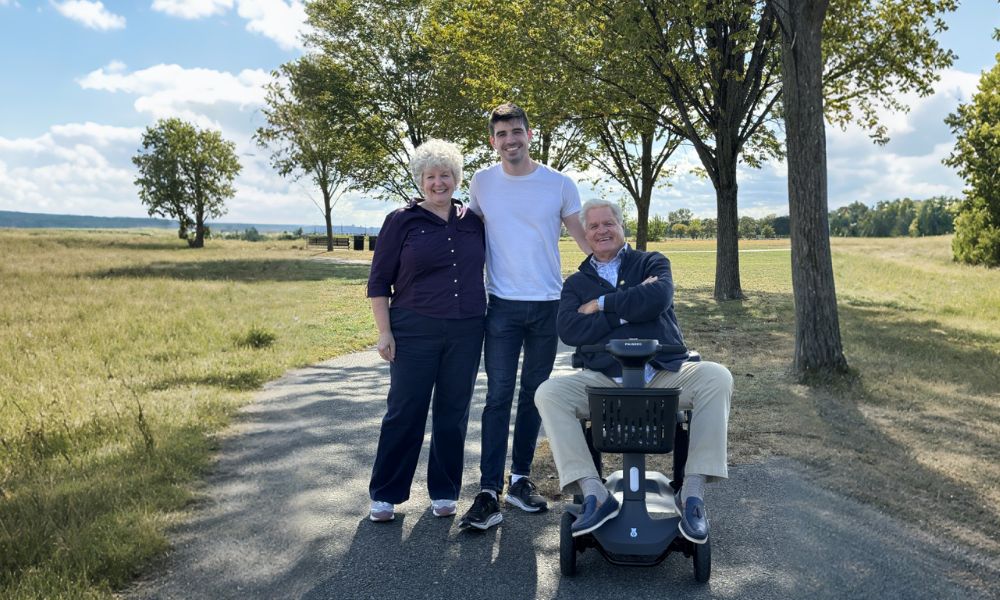 Man driving a four-wheel scooter for a walk with his family